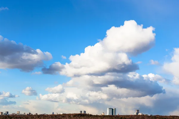 Grandes nubes de cúmulos en el cielo sobre casas y bosques —  Fotos de Stock