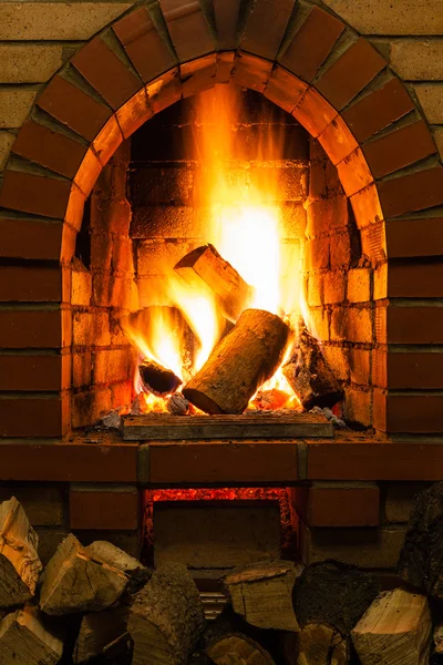 Brennholz und Feuer im Kamin — Stockfoto