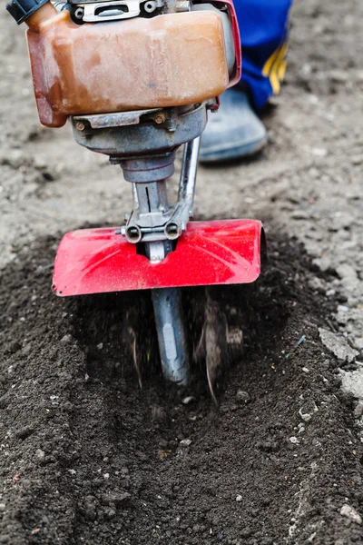 Farmer plows field by tiller in spring — Stock Photo, Image