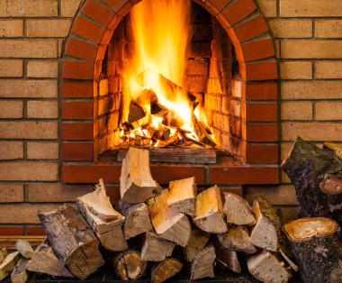 stack of firewood and fire in brick fireplace clipart