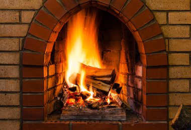 tongues of fire in indoor brick fireplace clipart