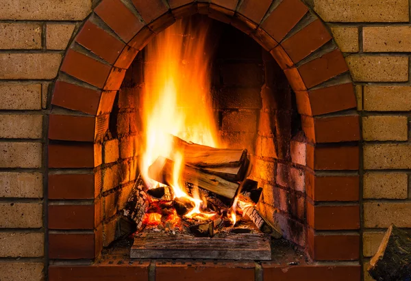 Lenguas de fuego en chimenea de ladrillo interior —  Fotos de Stock