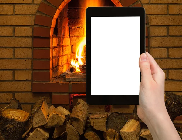 Tourist photographs fireplace on tablet pc — Stock Photo, Image