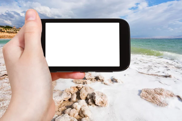 Tourist photographs salt coastline of Dead Sea — Stock Photo, Image