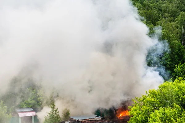 fire and gray smoke in urban parking area