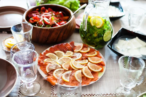 Assiette avec des tranches de saumon et des salades sur la table — Photo