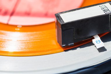 headshell of record-player on orange vinyl disc clipart