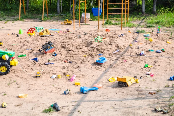 Brinquedos esquecidos no playground areia ao ar livre — Fotografia de Stock