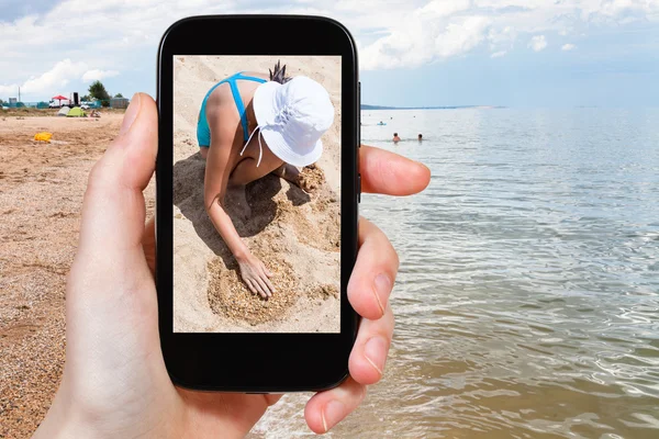 Tourist photographs girl playing with sand — Stock Photo, Image