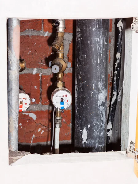 Contadores de água residenciais em tubos em nicho — Fotografia de Stock
