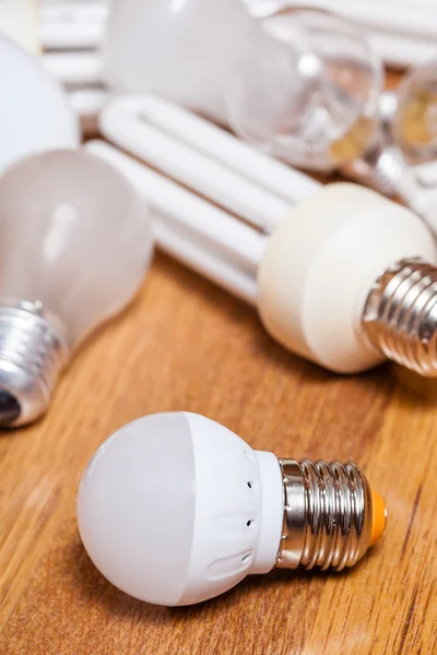 Энергосберегающая светодиодная лампа и куча старых ламп — стоковое фото