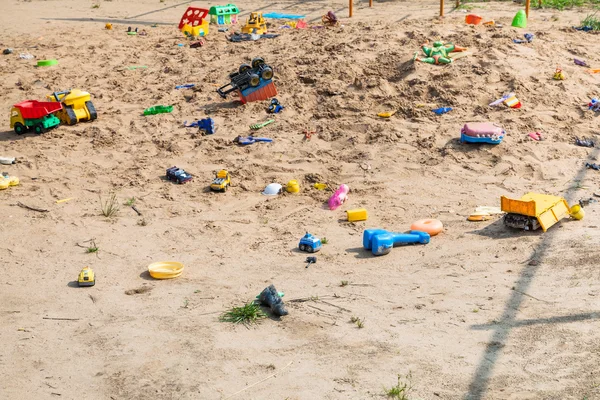 Abandoned toys in outdoor sand playground — Stock Photo, Image
