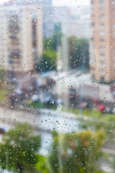 Gotas de chuva em vidro de janela e rua turva — Fotografia de Stock