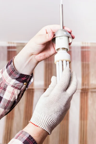 Electrician changing fluorescent lamp in holder — Stock Photo, Image