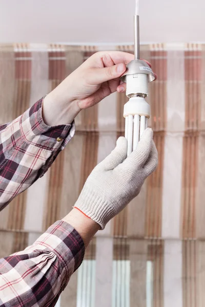 Elektriker montiert Leuchtstofflampe in Lampenfassung — Stockfoto