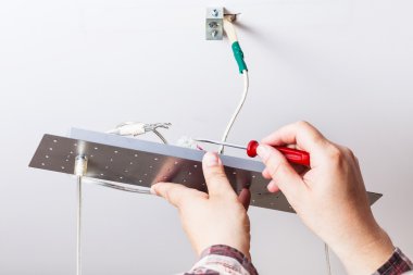 Elektrikçi kablo tavan lambası giderir.