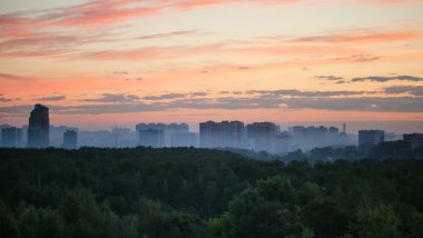 woods ve şehir üzerinde erken gündoğumu ve sabah sis