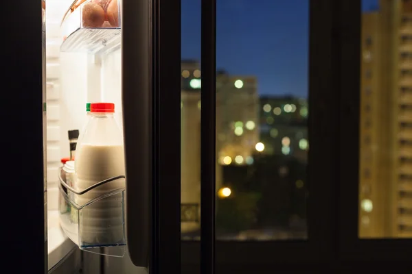 Dörren till hem kylskåp med mjölkflaskor i natt — Stockfoto