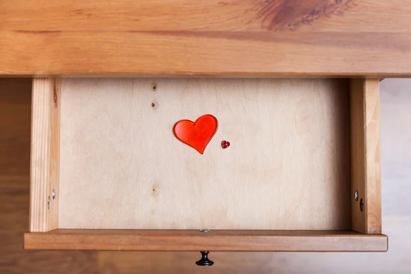 Two red glass hearts in open drawer — Stock Photo, Image