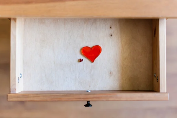 Little and big glass hearts in open drawer — Stock Photo, Image