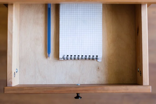 Caneta moderna e caderno quadrado em gaveta aberta — Fotografia de Stock