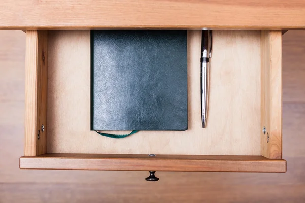 Moderne pen en notitieblok in open lade — Stockfoto