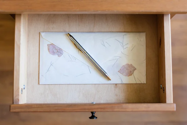 Silver pen on vintage envelope in open drawer — Stock Photo, Image