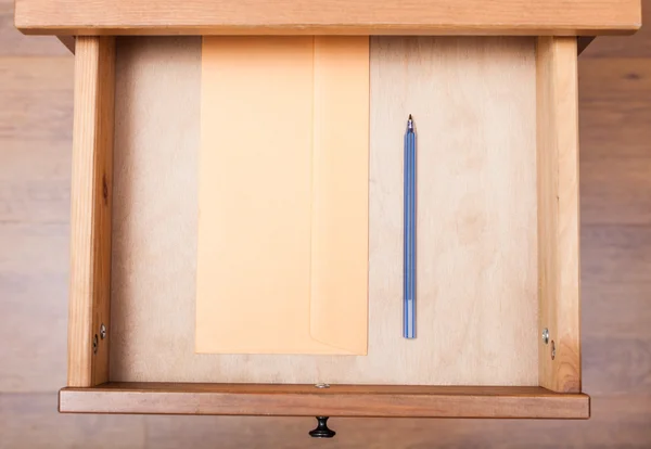 Caneta azul e envelope em gaveta aberta — Fotografia de Stock
