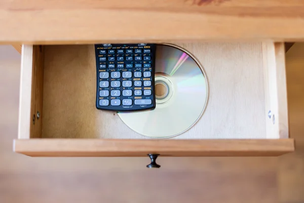Wissenschaftlicher Taschenrechner und eine CD in offener Schublade — Stockfoto