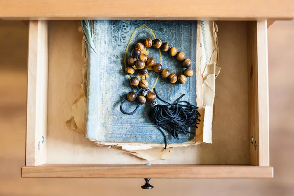 Açık drawe eski püskü dini kitap üzerinde tespih — Stok fotoğraf