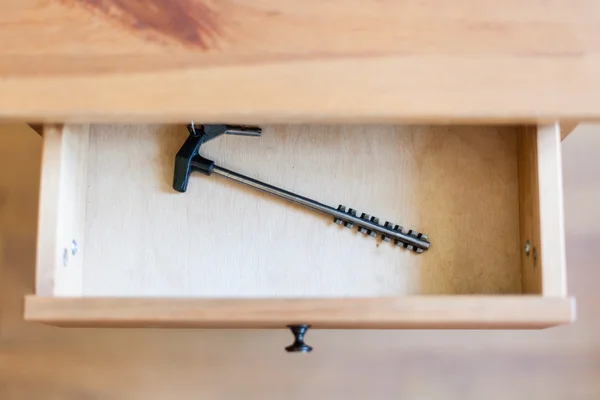 Long latchkey in open drawer — Stock Photo, Image