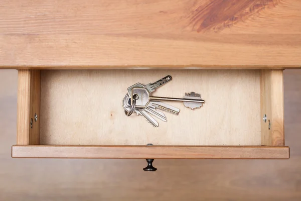 Bunch of door keys on ring in open drawer — Stock Photo, Image
