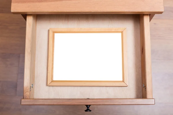 Wooden picture frame in open drawer — Stock Photo, Image