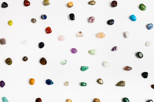 many natural mineral gem stones arranged on white