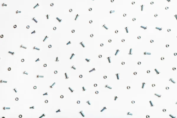 Top view of many steel bolts and nuts on white — Stock Photo, Image