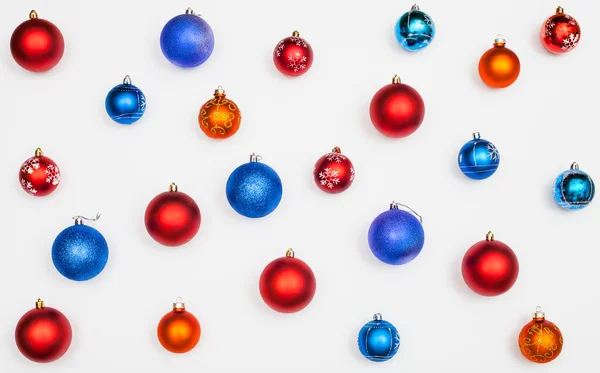 Muitas bolas de Natal azuis, vermelhas e laranja no branco — Fotografia de Stock