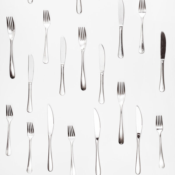 table knives and forks arranged on white