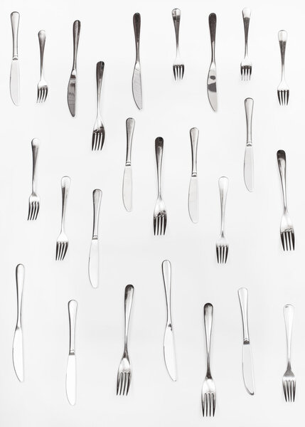 vertical set of table knives and forks on white