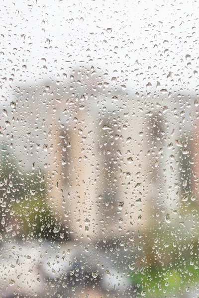 Vista de gotas de lluvia en la ventana de la casa de apartamentos — Foto de Stock