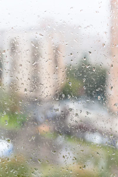 Weergave van natte vensterglas van appartementenhuis — Stockfoto