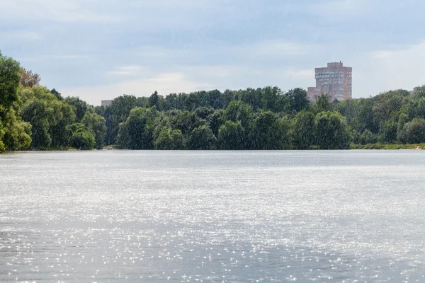 Летний ливень на городской пруд — стоковое фото