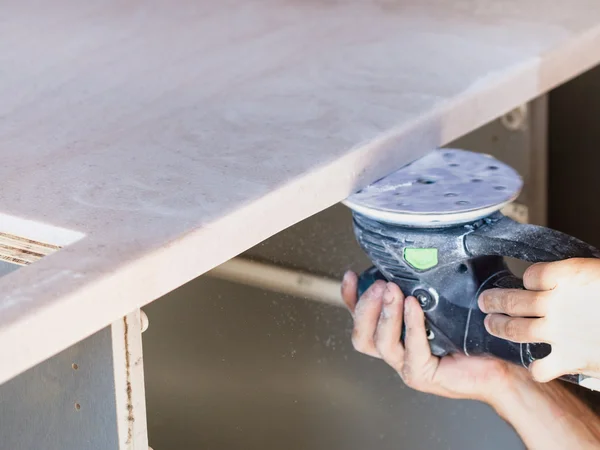 Worker sanding worktop from artificial stone — Stock Image Worker sanding worktop from artificial stone Stock Image