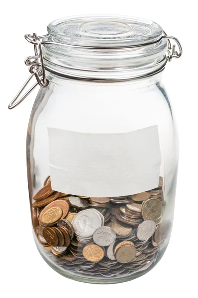 Closed glass jar with empty label and saved coins — Stock Photo, Image