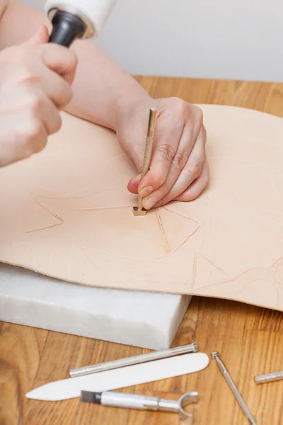 Craftsman puts stamping on leather — Stock Photo, Image