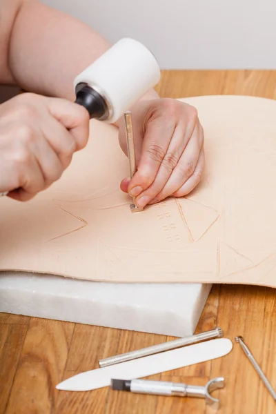 Craftsman puts picture on leather — Stock Photo, Image