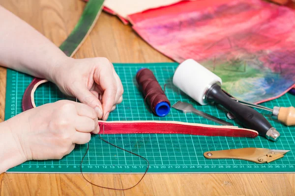 Hantverkare gör läderbälte för nya präglade väska — Stockfoto