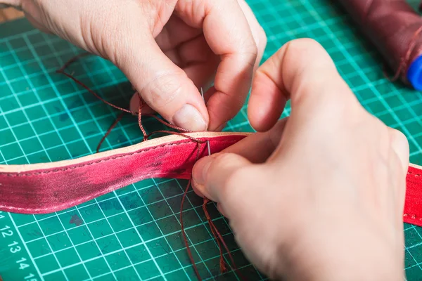 Craftsman stitches new leather belt close up — Stock Photo, Image