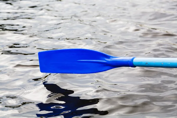 Весло над водой во время гребли лодки — стоковое фото
