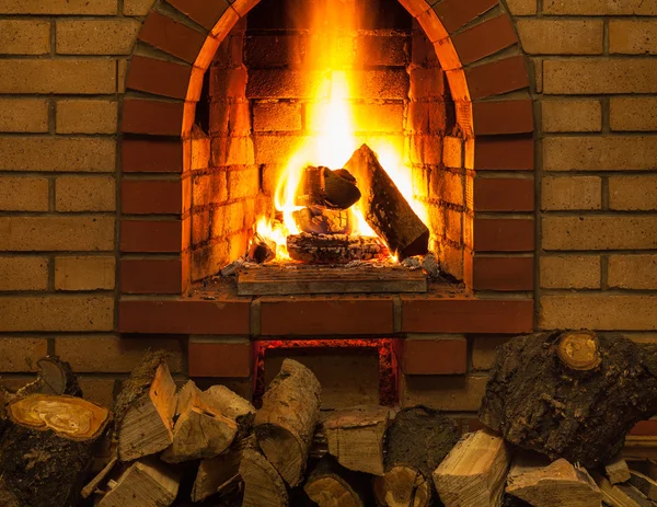 Pile de bois de chauffage et langues de feu dans la cheminée — Photo