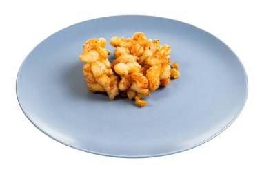 Çin mutfağı. Beyaz arka planda izole edilmiş mavi tabakta hamurda kızartılmış bir yığın kerevit boynu.